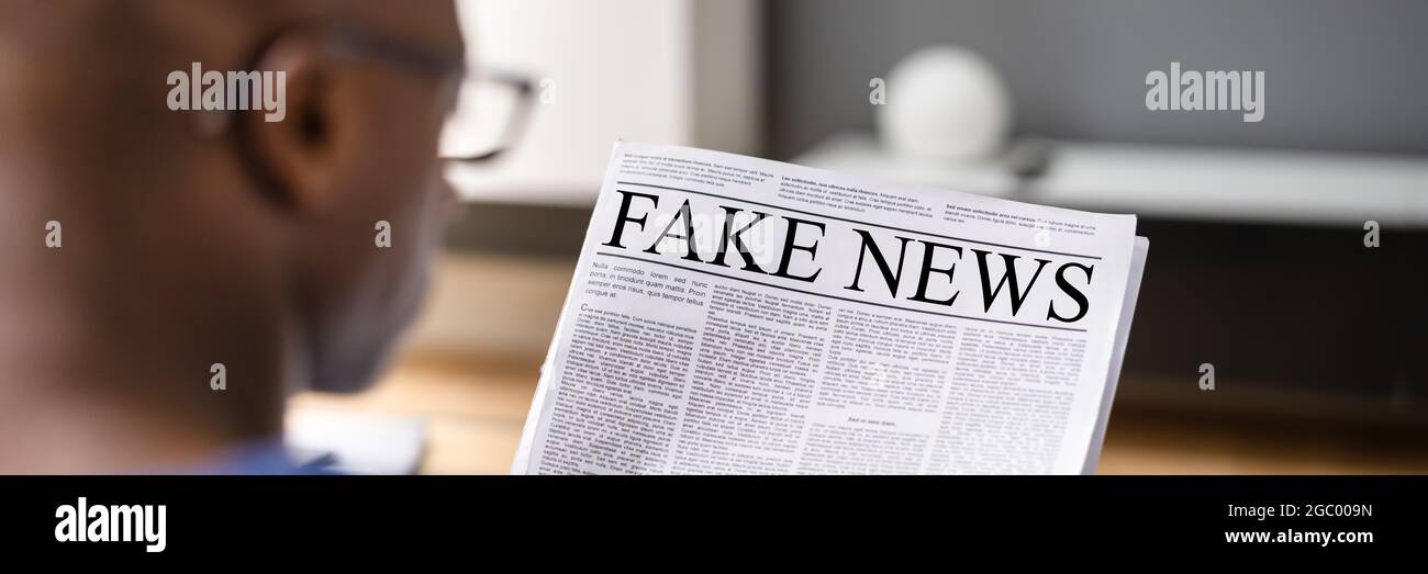 African Man Reading Fake News Newspaper Headline Foto Stock