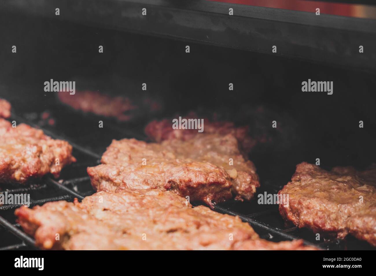 Hamburger alla griglia con formaggio gorm che si fonde sulla carne. Carne cotta alla griglia e carbone. Scaldare la carne per cucinare. Carne alla griglia per bu Foto Stock