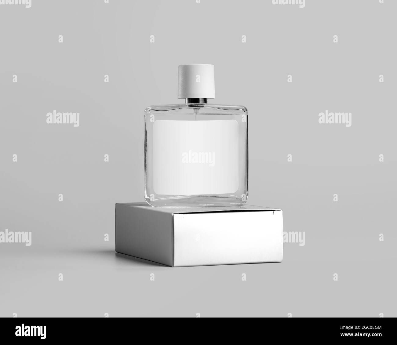 Un prodotto di marca mockup, una bottiglia di profumo in vetro trasparente con etichetta, si trova su una scatola di cartone con spazio per il design. Modello contenitore fiale wi Foto Stock