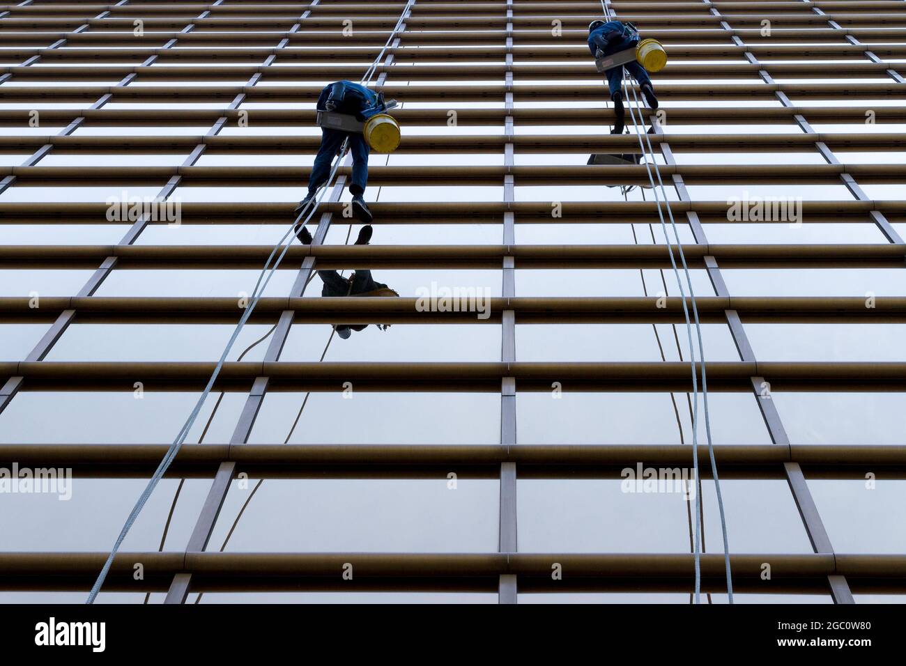 Pulitori per finestre con corde per abbaiare un edificio a Yokohama, Kanagawa, Giappone. Foto Stock