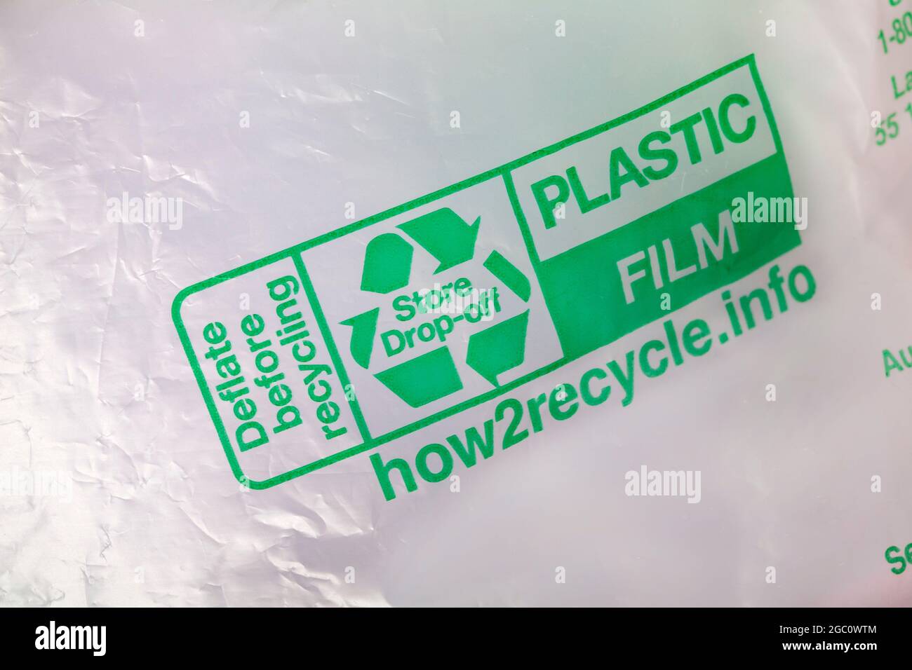 Sgonfiare prima del riciclaggio con il logo di riciclaggio logo di riciclaggio Mobius Loop simbolo conservare goccia off su pellicola di plastica imballaggio Foto Stock