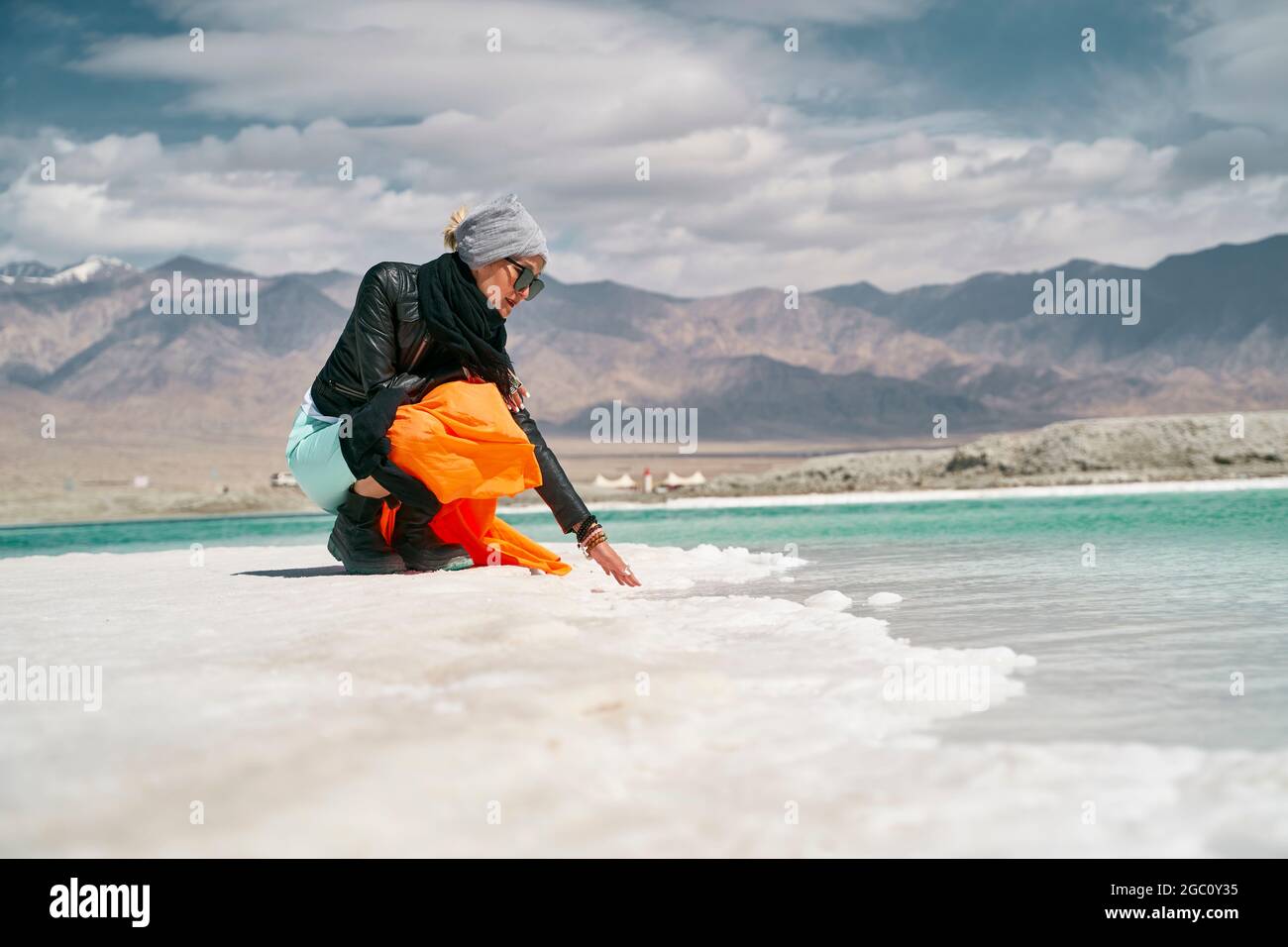 donna asiatica turista femminile che tocca l'acqua di un lago salato Foto Stock