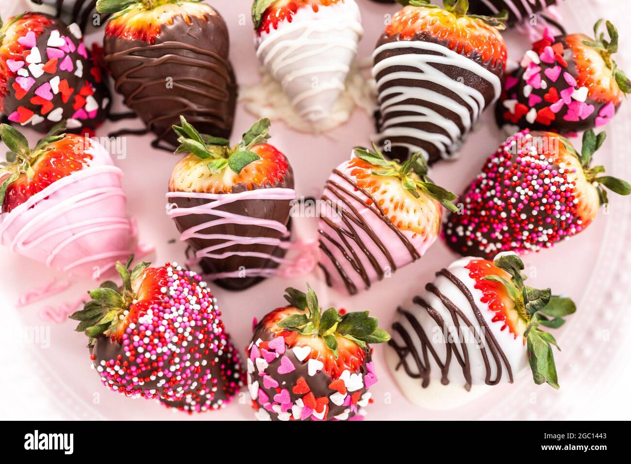 Varietà di fragole ricoperte di cioccolato su una base di torta rosa Foto  stock - Alamy