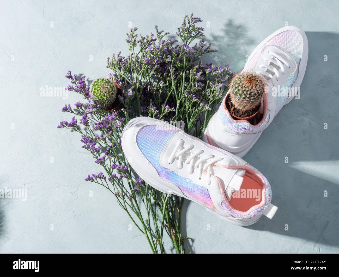 Sneaker bianche con paillettes e fiori viola su sfondo turchese Foto stock  - Alamy