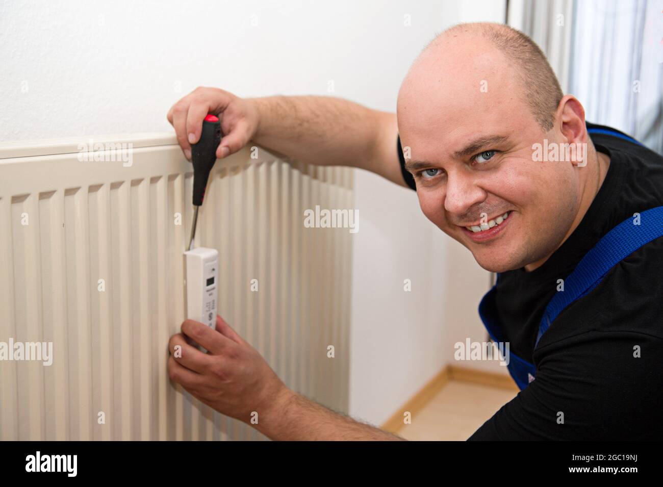 addetto alla sostituzione di un misuratore di calore Foto Stock