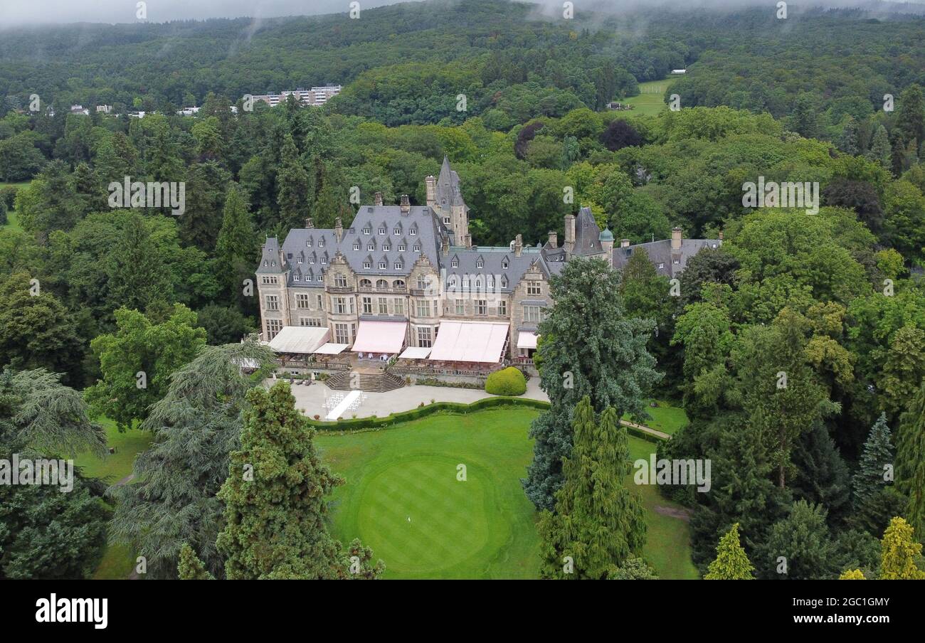 06 agosto 2021, Hessen, Kronberg: Circondato dal parco con campo da golf e alberi, è il 5 stelle superiore Schlosshotel Kronberg (shot con drone). Nonostante le restrizioni di Corona, una dozzina di lungometraggi sono stati girati in Assia dall'inizio della pandemia. Secondo il Ministero delle Arti, HessenFilm und Medien GmbH ha dodici produzioni cinematografiche tra febbraio 2020 e giugno 2021 con un bilancio complessivo di circa 3.4 milioni di euro. Si tratta della vita della principessa Diana ('Spencer', sparata a Kronberg). (A dpa 'dodici nuovi film con location in Hesse') Foto: Arne Dedert/dpa Foto Stock