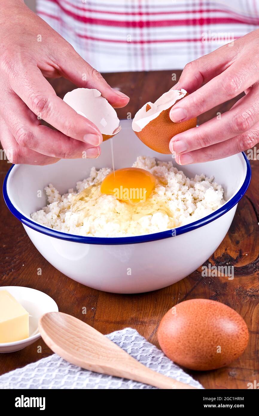 Preparare una pasta frolla aggiungendo l'uovo alla farina Foto Stock