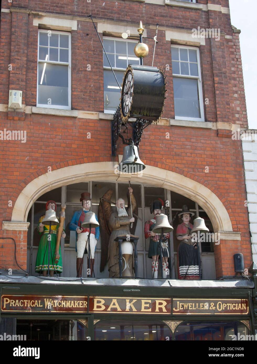 Cinque personaggi, tra cui Old Father Time e un soldato britannico, tutti in abiti tradizionali sopra un negozio a Gloucester nel Regno Unito Foto Stock