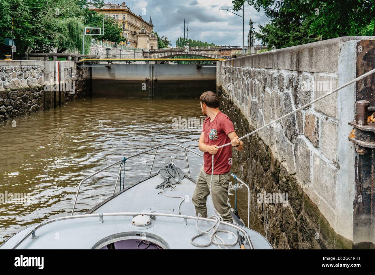 Uomo sulla barca in ascensore di blocco sul fiume Moldava, Praga, Repubblica Ceca.acqua transport.River crociera, sightseeing.Water lift processo da locking Complex.Motor Foto Stock