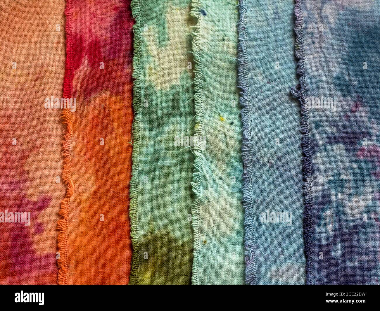 Closeup di tessuti colorati in cotone umido tinti a mano sovrapposti e sparati dall'alto Foto Stock