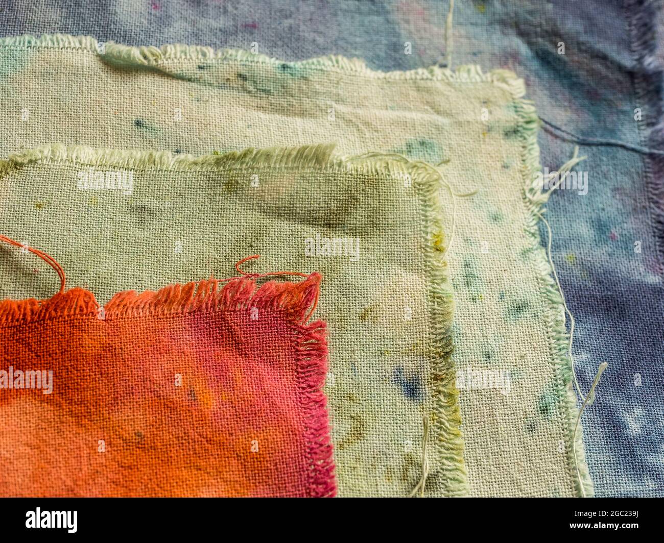 Closeup di tessuti colorati in cotone umido tinti a mano sovrapposti e sparati dall'alto Foto Stock