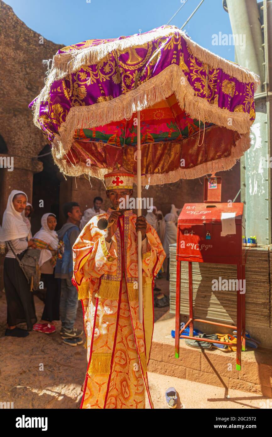 LALIBELA, ETIOPIA - GENNAIO 2020: Un sacerdote etiope non identificato tiene un ombrellone e un corno alle festività di Lalibela Foto Stock