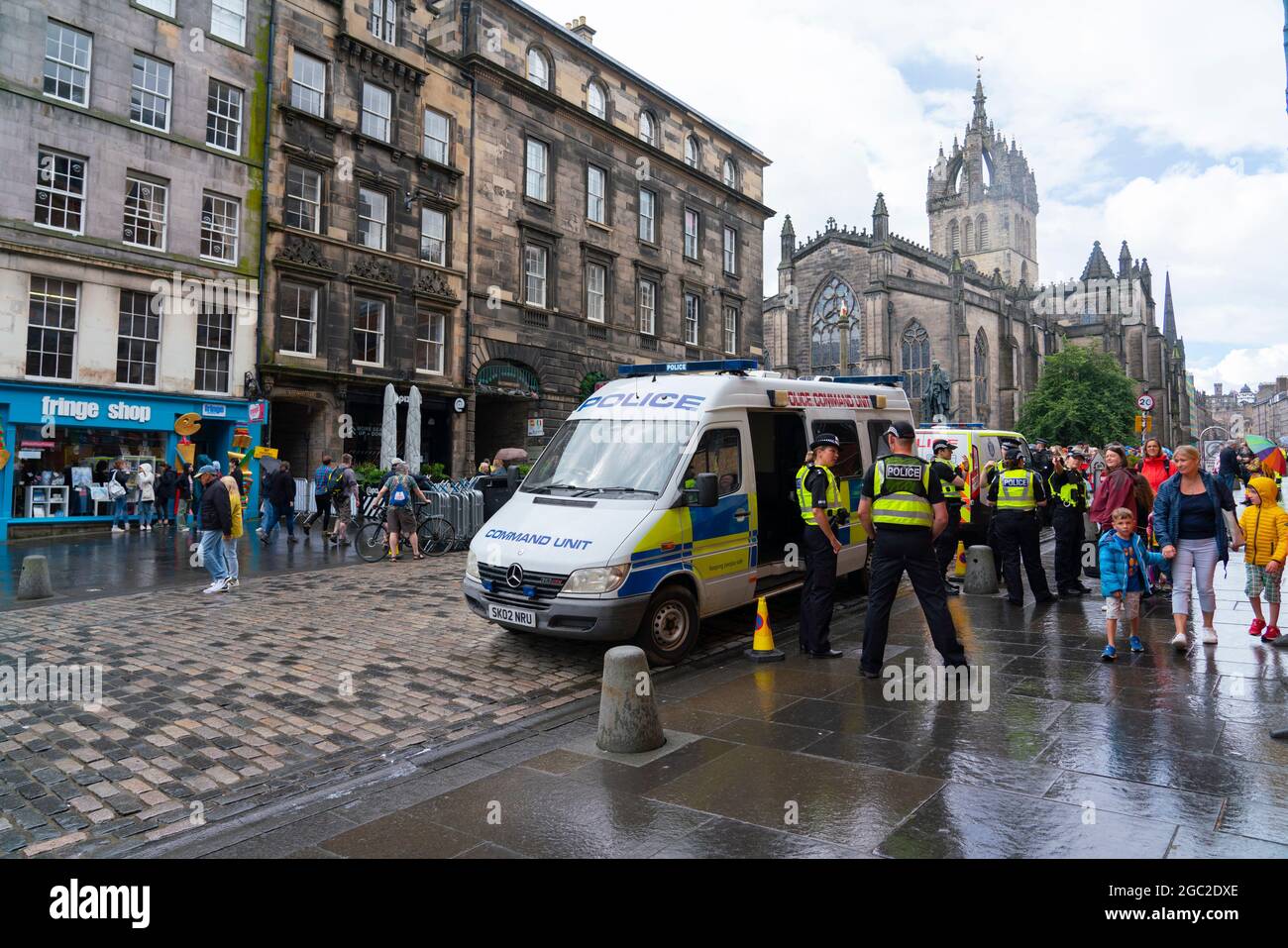 Edimburgo, Scozia, Regno Unito. 6 agosto 2021. Immagini dal Royal Mile nella città vecchia di Edimburgo il giorno di apertura del Festival della frangia di Edimburgo 2021. Il festival sembra molto diverso da due anni fa . Sono consentiti pochissimi spazi per spettacoli di strada e sono evidenti meno turisti. Anche un'elevata visibilità della polizia, ci sono più agenti di polizia che artisti per strada, è in netto contrasto con gli anni precedenti. PIC; polizia parcheggiata su Royal Mile dove gli artisti di strada normalmente si esibiscono. Iain Masterton/Alamy Notizie dal vivo. Foto Stock