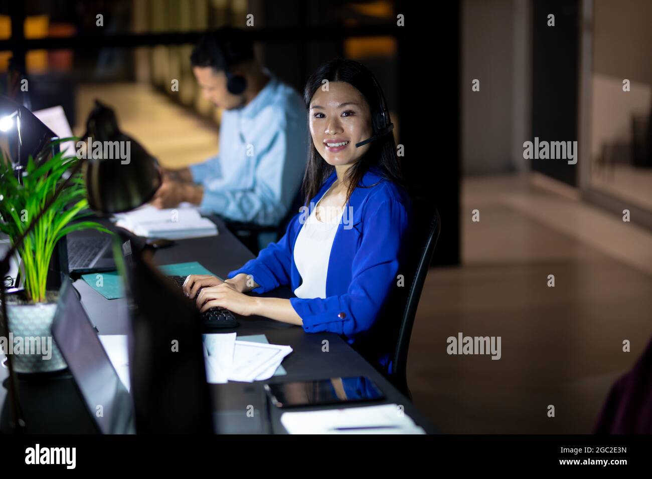 Ritratto di donna d'affari asiatica che lavora di notte indossando la cuffia Foto Stock