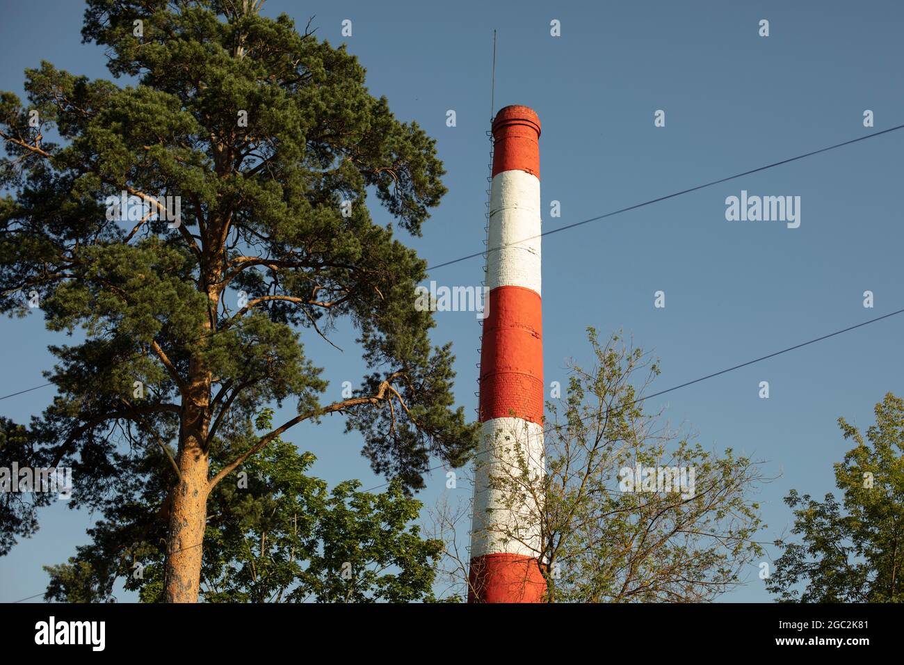 Tubo industriale della caldaia. Camino rosso e bianco in città. Tubo in mattoni per la rimozione del vapore. Foto Stock