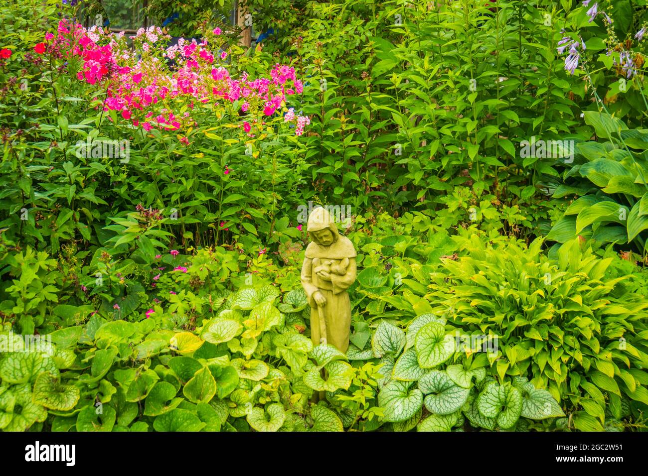 Tranquillo giardino con statua di San Francesco d'Assisi Foto Stock