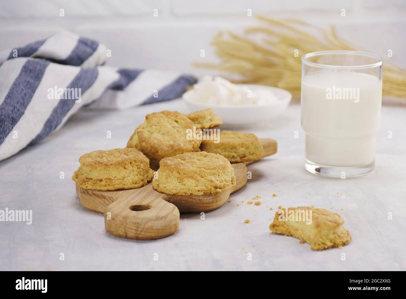 Biscotti su tavola di legno con un bicchiere di latte su un tavolo leggero, cucina Foto Stock