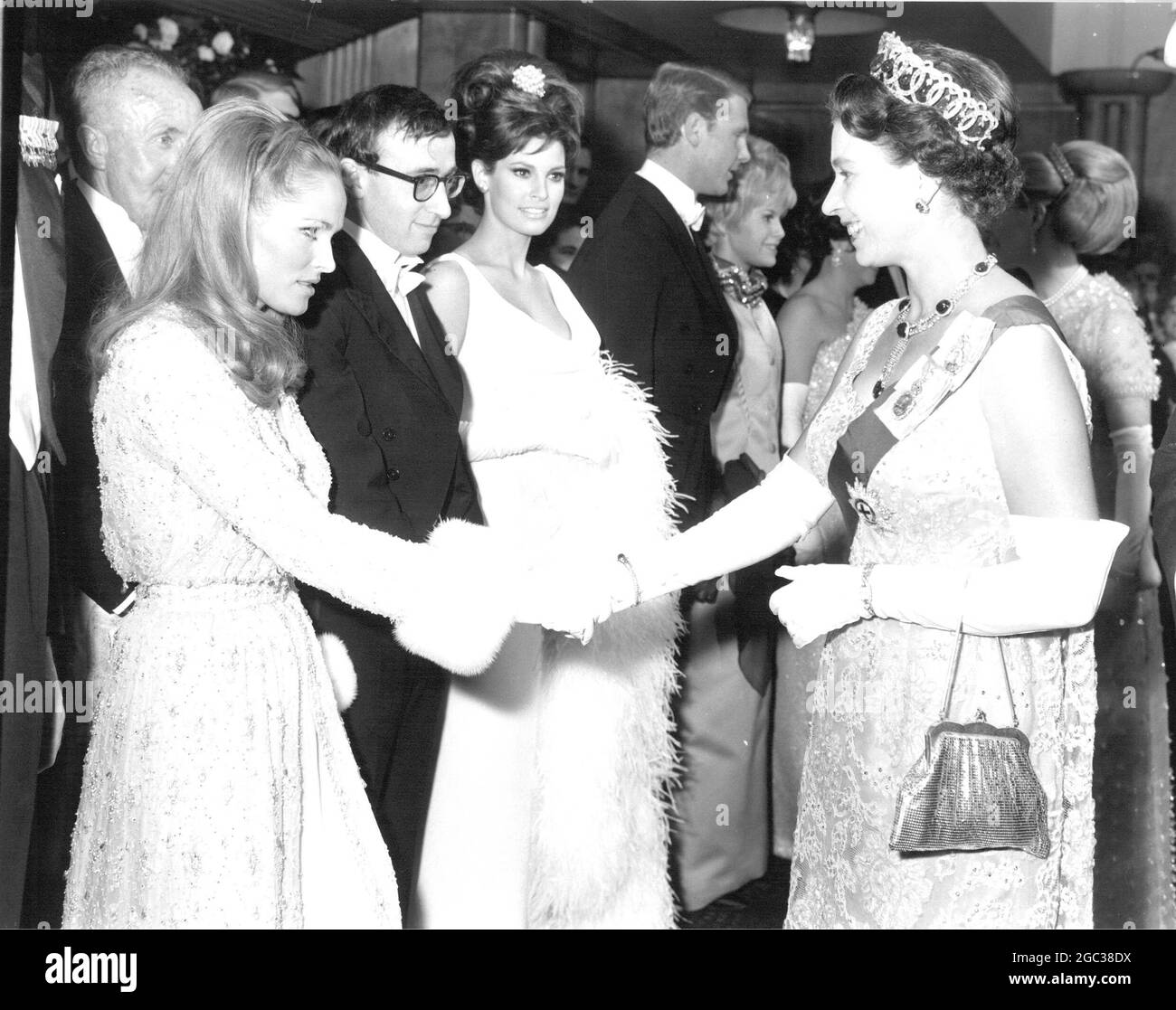 La regina britannica Elizabeth II stringe le mani con l'attrice Ursula Andress, con Woody Allen e Raquel Welch alla ricerca, prima dell'inizio del film Royal Film Preforemance 1966 nato Free all'Odeon Theatre di Leicester Square, Londra. Marzo 1966. Foto Stock
