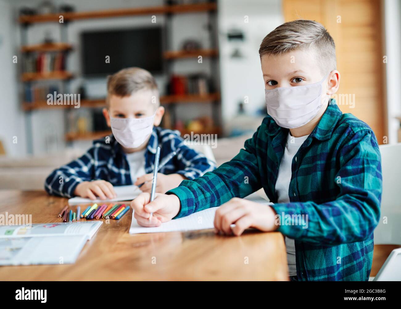 bambino ragazzo compiti schold istruzione classe studiare infanzia maschera protezione virus corona casa Foto Stock