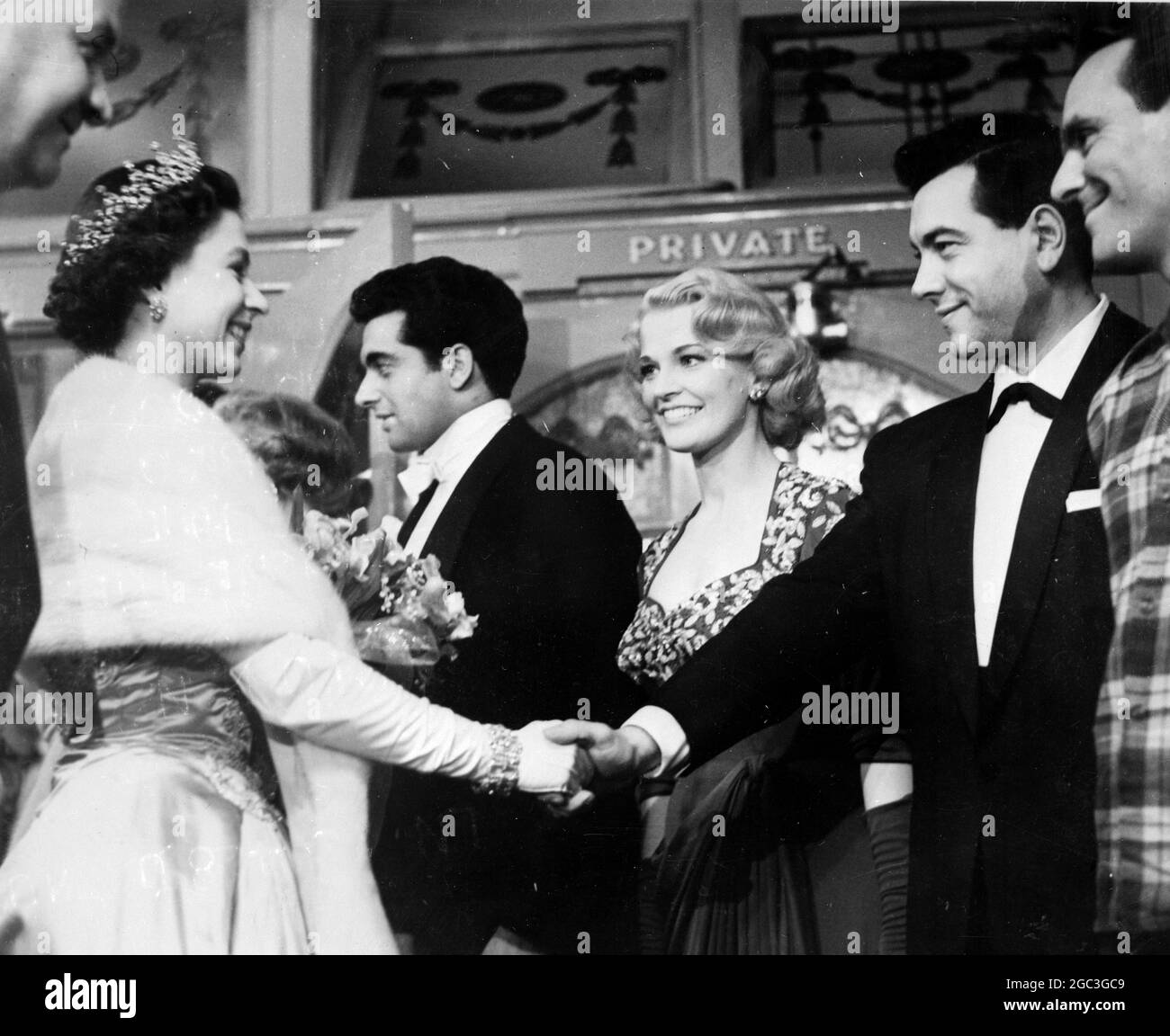 La regina Elisabetta II chiacchiera con le stelle schierate nel foyer del teatro dopo il Royal Command Variety Show. Joan Regan guarda come sua Maestà scuote le mani con la star del canto americana Mario Lanza - 19 novembre 1957. ©TopFoto Foto Stock
