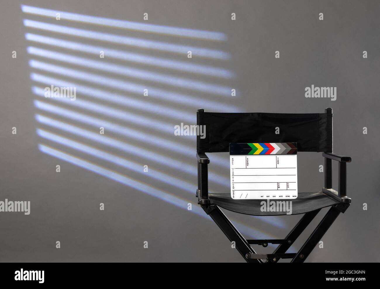 sedia del direttore con clapperboard su sfondo grigio di studio fotografico Foto Stock