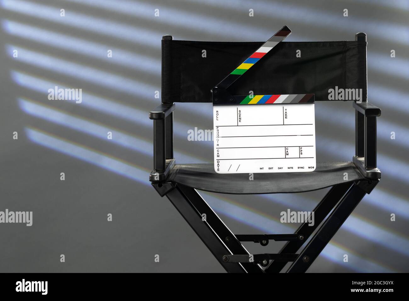 sedia del direttore con clapperboard su sfondo grigio di studio fotografico Foto Stock