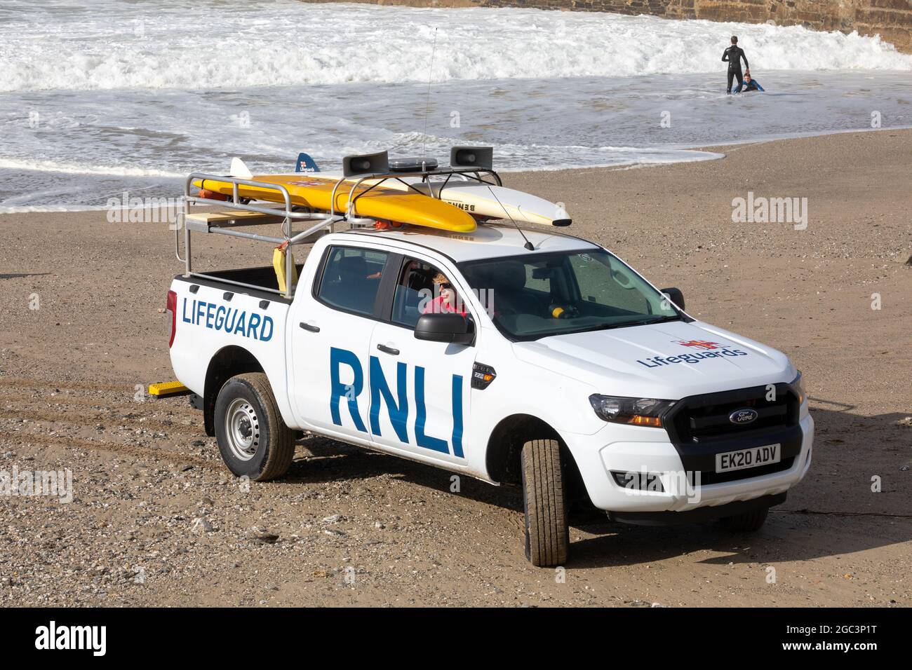 Porteath, Cornovaglia, Regno Unito. 6 agosto 2021, le famiglie hanno goduto il sole del tardo pomeriggio sulla spiaggia all'alta marea in Portreath, Cornovaglia mentre la RNLI guardava sopra. Tempo non regolato è previsto per i prossimi giorni.Credit: Keith Larby/Alamy Live News Foto Stock