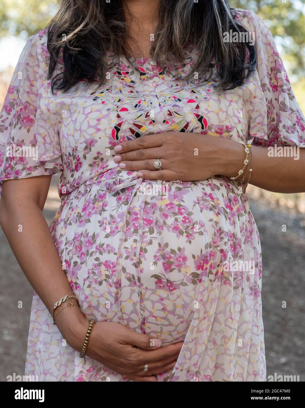 Mese 8 di donne in attesa grembo incinta tenuto dalle mani amorose della mamma. Foto Stock