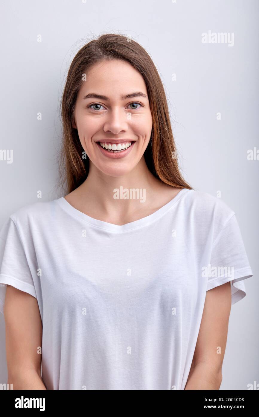 Buona-Looking femmina in outfit casual guardando la macchina fotografica sorridente accogliente, isolato su sfondo bianco studio, ritratto di attraente signora con naturale b Foto Stock