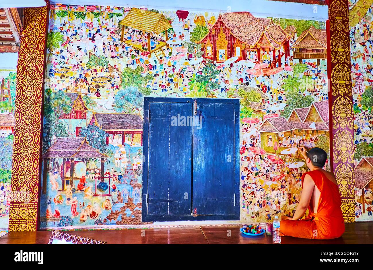 LAMPANG, THAILANDIA - 8 MAGGIO 2019: Il monaco di Bhikkhu ripristina murales medievali di scene di vita Lanna sulla parete dello storico tempio di Wat Pratu Pong, l'8 maggio Foto Stock