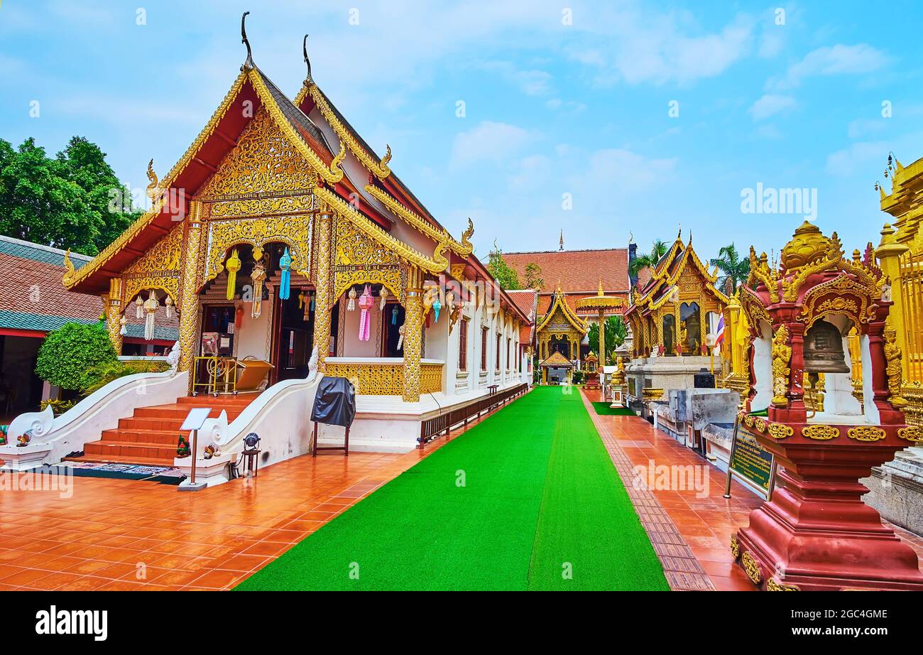 Tempio di Phra Chao Lawo con pregevole motivo dorato sulla facciata, colonne snelle, lanterne Lanna colorate, tetto di pyathat (timpano) con serpenti Naga su chofa Foto Stock