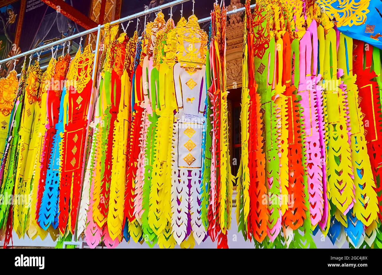 Le colorate bandiere rituali di Lanna pendono sulla terrazza del Viharn Luang di Wat Phra That Hariphunchai Tempio, Lamphun, Thailandia Foto Stock
