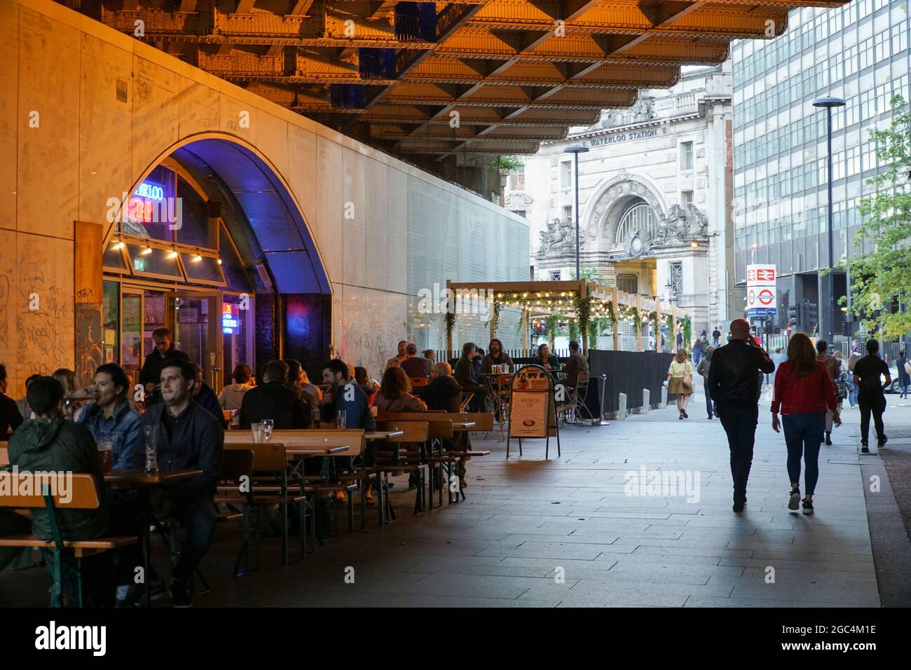 Londra, Regno Unito, 6 agosto 2021: Venerdì sera sulla South Bank di Londra consente ai bevitori di avere tempo per una pinta e per socializzare al Waterloo Tap, con la stazione di Waterloo in background pronta a consentire ai bevitori di tornare a casa in modo sicuro con i mezzi pubblici. Anche se il footfall non è così alto come nei periodi pre-pandemic, ci è ancora una buona vibrazione di notte di venerdì come la gente attende con impazienza al fine settimana. Anna Watson/Alamy Live News Foto Stock