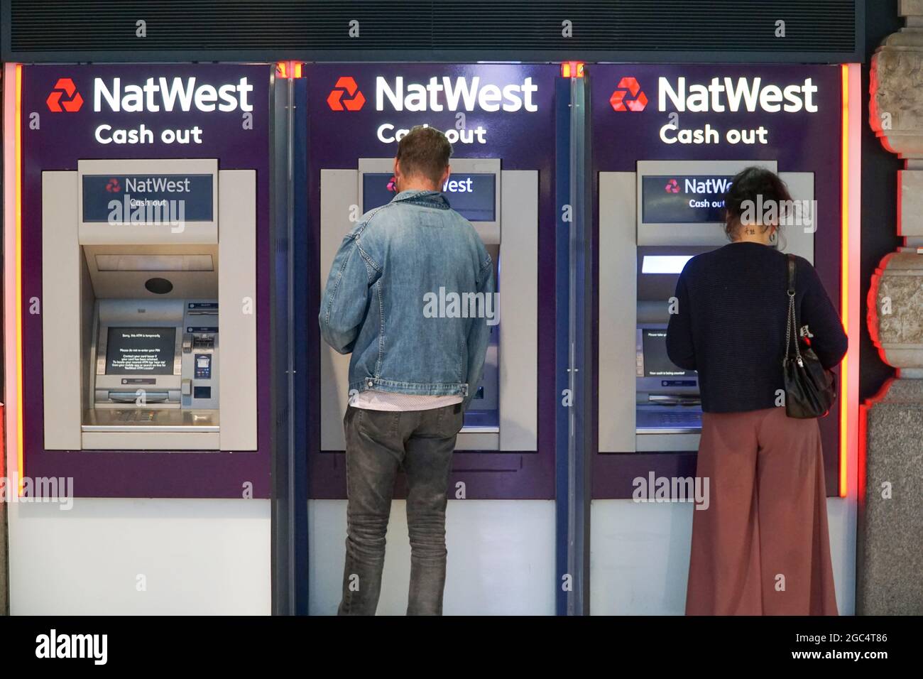 Londra, Regno Unito, 6 agosto 2021: Due persone utilizzano i cashpoint NatWest alla stazione di Waterloo. La banca, che è per lo più di proprietà del governo, è recentemente tornata alla redditività ed è destinato a pagare un dividendo elevato al Tesoro. Anna Watson/Alamy Foto Stock