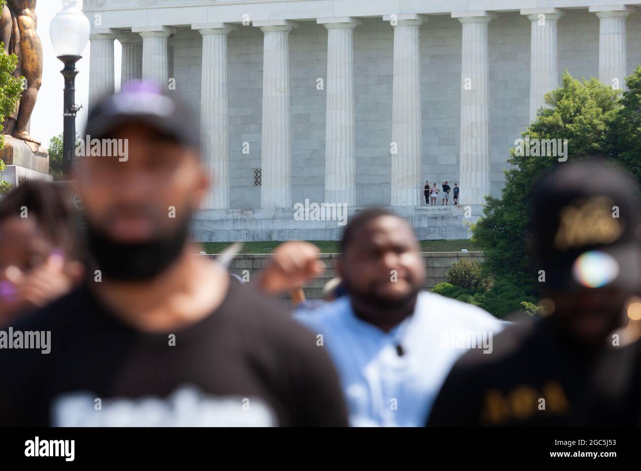 Washington DC, USA, 6 agosto 2021. Nella foto: I turisti al Lincoln Memorial guardano come una marcia Freedom Friday passa lungo il tragitto per l'aeroporto. I manifestanti in seguito hanno bloccato il traffico all'aeroporto nazionale di Reagan nel tentativo di fermare i senatori in partenza per la reclusiva perché non avevano ancora agito per proteggere i diritti di voto. Circa 25 dimostranti sono stati arrestati in questa azione di disobbedienza civile. Credit: Alison Bailey / Alamy Live News Foto Stock