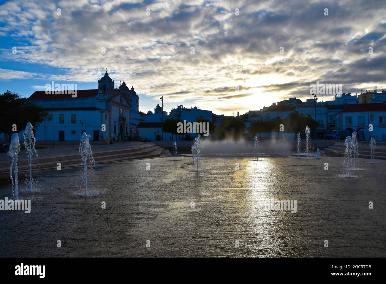 Paesaggio urbano nel centro storico della città al tramonto, fontana nella piazza con la chiesa di Santa Maria edificio, Lagos, Algarve, Portogallo, Foto Stock