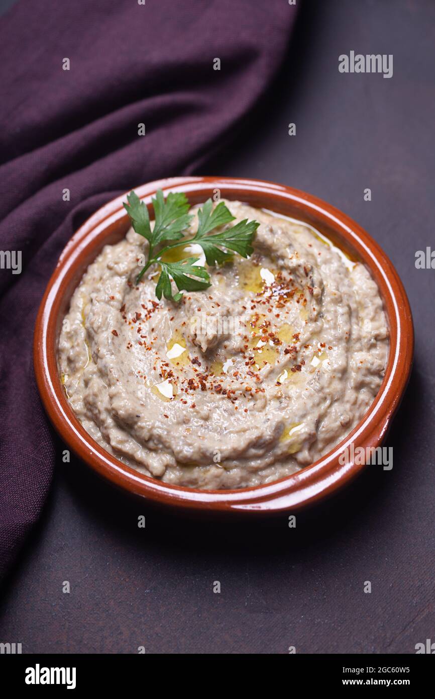 Baba ganoush antipasto, Ezme della cucina orientale, Levantine con erbe a base di melanzane al forno con pasta di sesamo su sfondo scuro Foto Stock