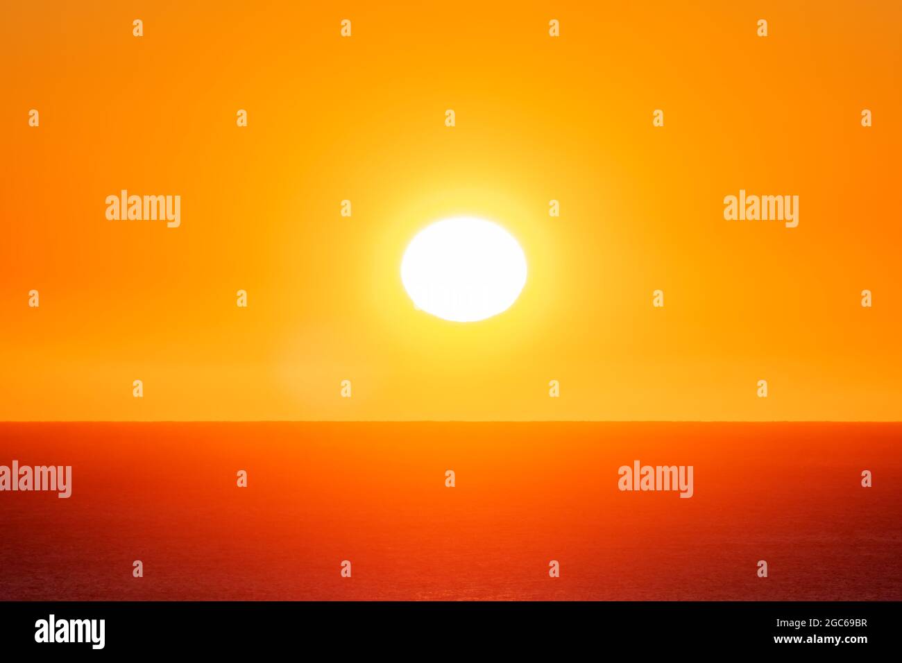 Sole appena sorto sull'orizzonte sopra il mare in una giornata estiva. Foto Stock