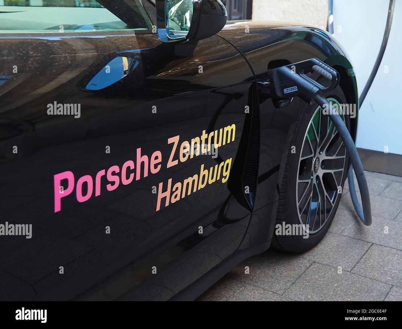 Auto Porsche nera presso una stazione di ricarica elettrica ad Amburgo in Germania Foto Stock