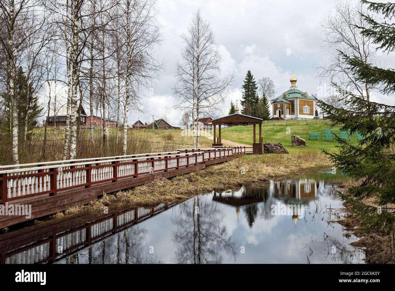 Paesaggio primaverile. Monastero di Olginsky nella prima primavera, la Chiesa di San Nicola il Wonderworker si riflette nelle acque del fiume Volga, che orig Foto Stock