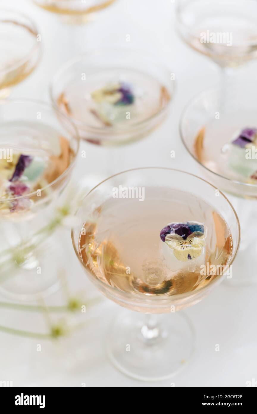 Vino rosato frizzante con contorno floreale commestibile Foto Stock