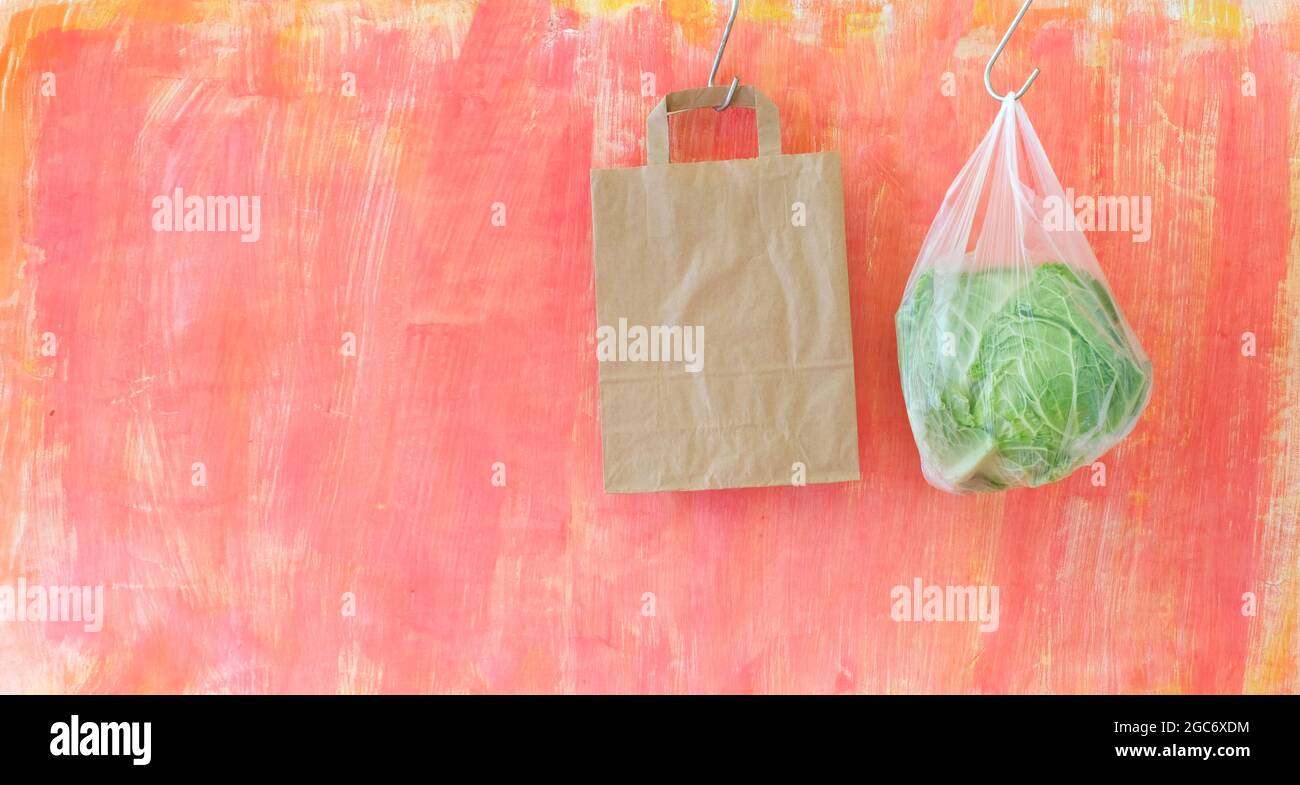 cavolo in un sacchetto di plastica e in un sacchetto di carta vuoto, divieto di plastica per il concetto di imballaggio alimentare Foto Stock