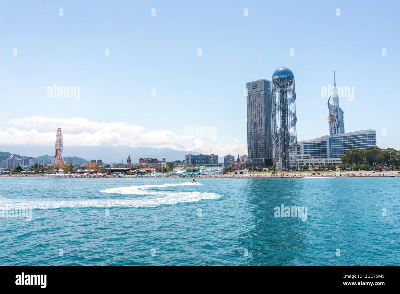 Batumi, Georgia - 2 luglio 2021: Costa di Batumi. Popolare località georgiana sul Mar Nero. Vista panoramica della ruota panoramica, della torre alfabetica, dei grattacieli e della spiaggia dal mare. Foto Stock