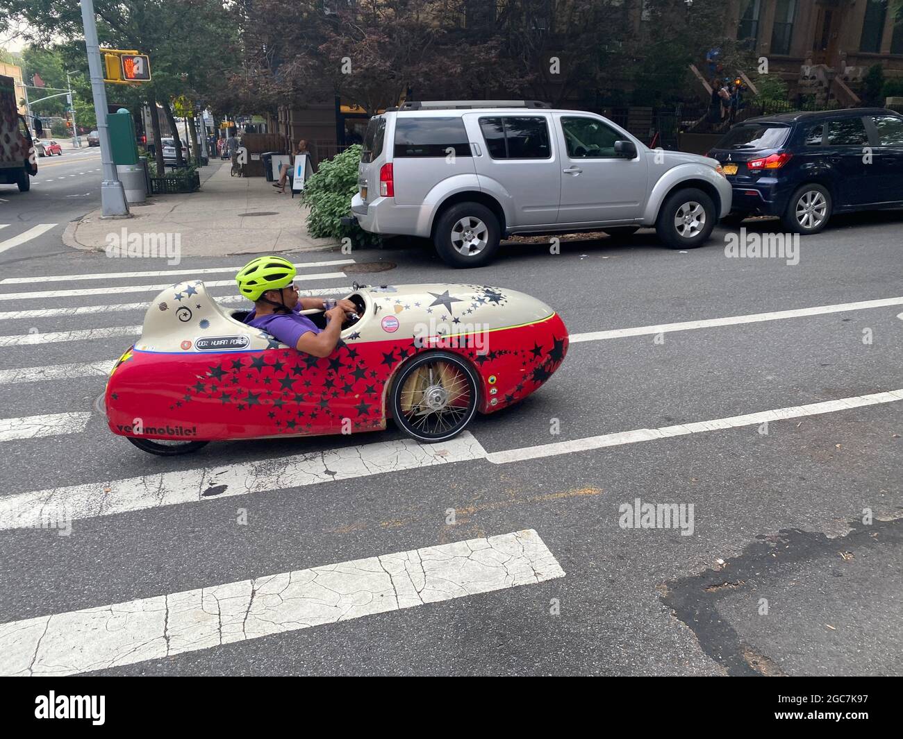 L'uomo corre in una piccola auto a razzo a propulsione umana chiamata Velomobile a Park Slope, Brooklyn, New York. Foto Stock