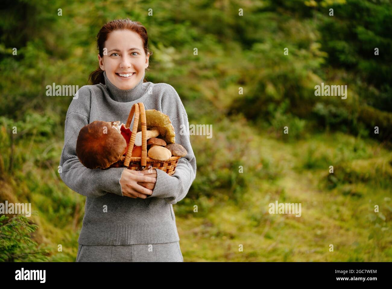 La giovane donna ha raccolto molti funghi nella foresta Foto Stock