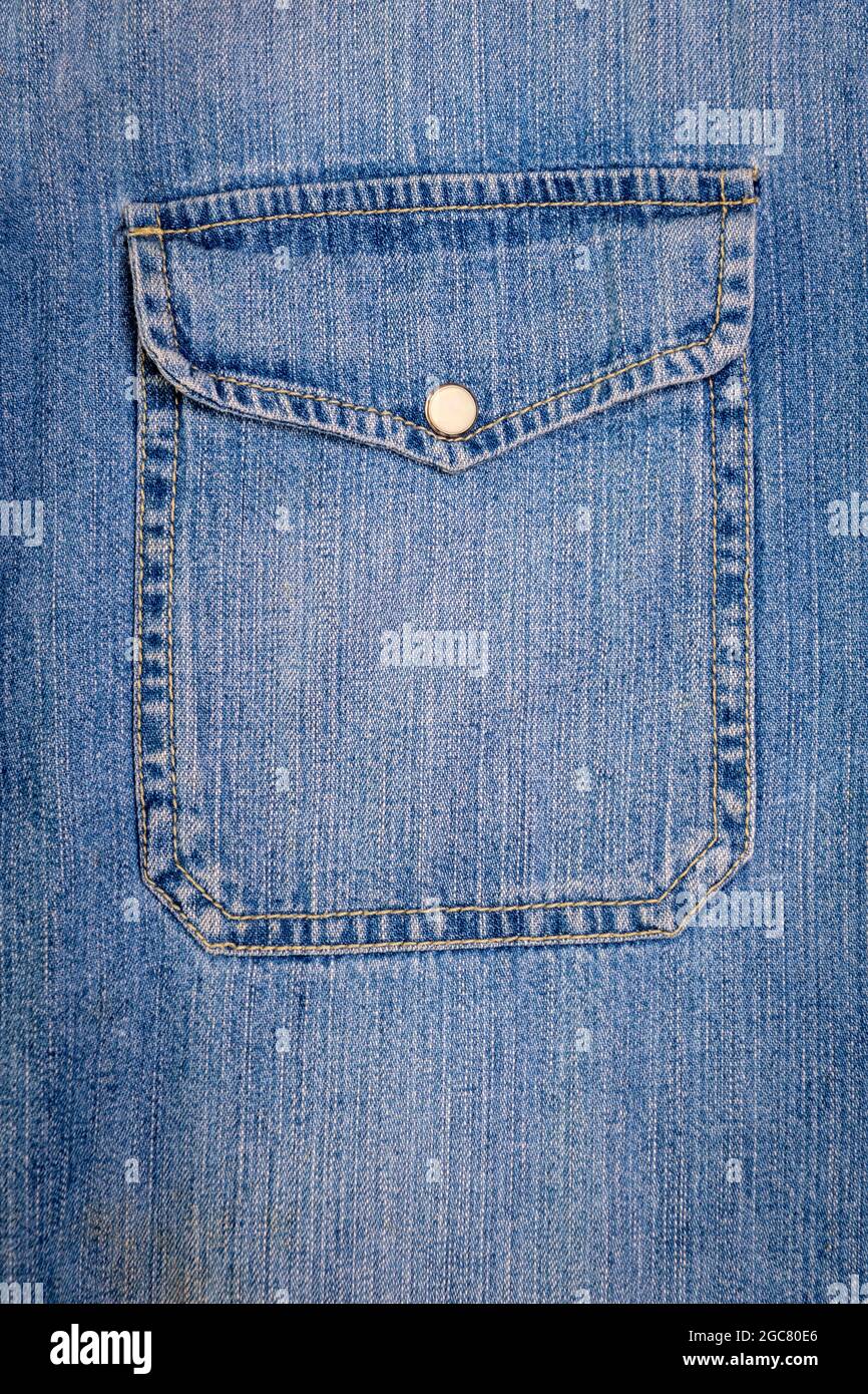 Texture jeans blu. Parte di una giacca in jeans con tasca da vicino. Foto Stock