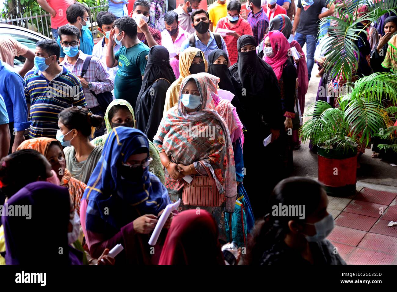 Le persone si accodano per ricevere un colpo del vaccino Mordana COVID19 durante una campagna di vaccinazione di massa presso il centro di vaccinazione degli shamoli a Dhaka, Bangladesh, il 7 agosto 2021. Secondo la direzione Generale dei servizi sanitari del Bangladesh (DGHS), il programma nazionale di vaccinazione di massa inizia con la sua campagna di vaccinazione volta ad iniettare 3.5 milioni di persone in sei giorni. Il Bangladesh ha registrato quasi 1.31 milioni di infezioni da coronavirus e 21,638 decessi dall'inizio della pandemia. Foto Stock