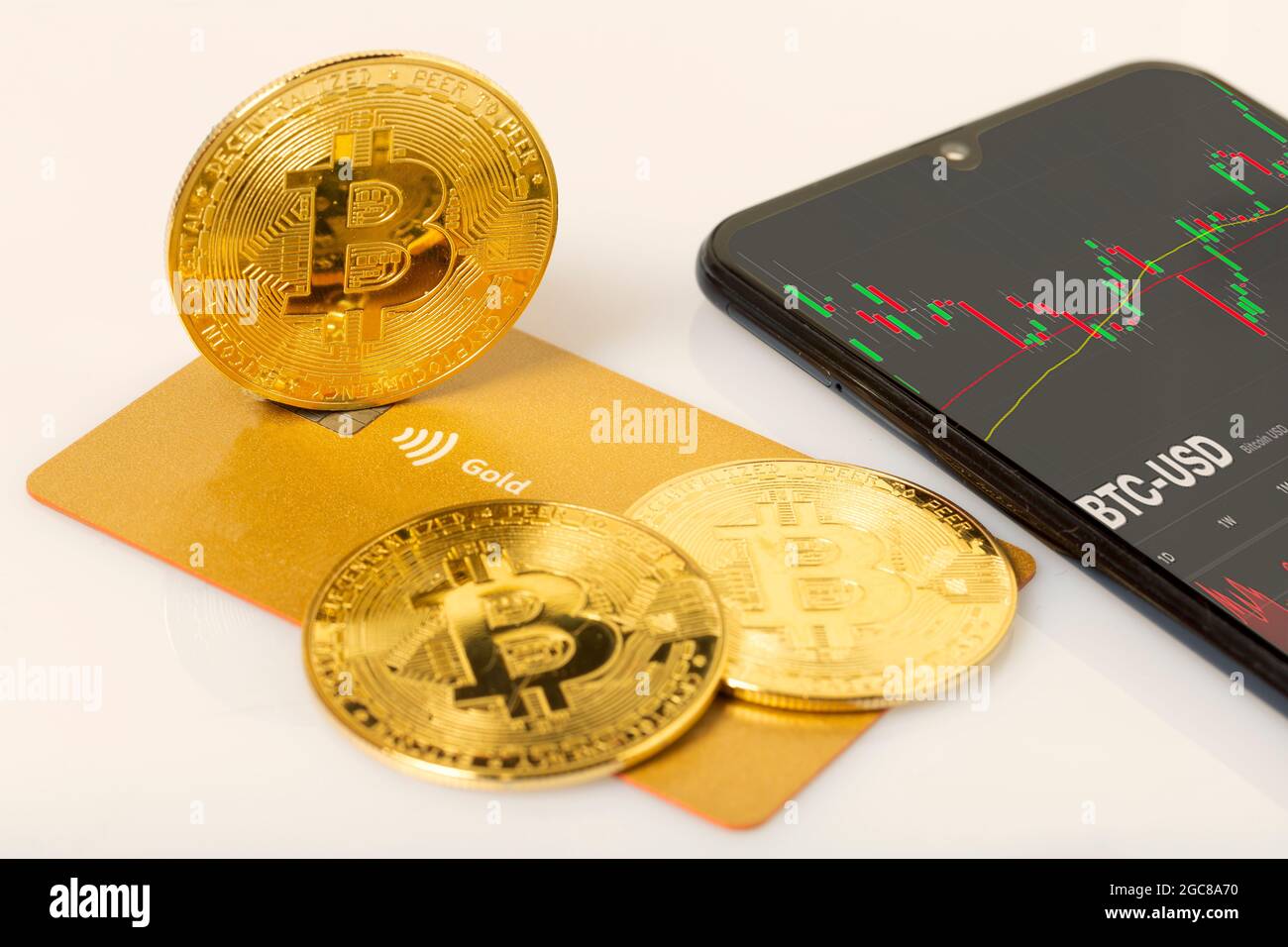 bitcoin su una carta di credito e uno smartphone con la carta commerciale sullo schermo - concetto Foto Stock