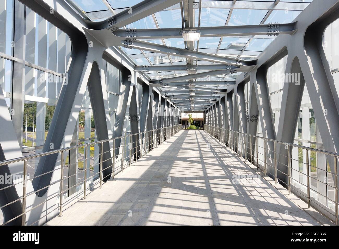 Ponte pedonale in vetro con travi metalliche all'interno. Prospettiva. Vista interna. Foto Stock
