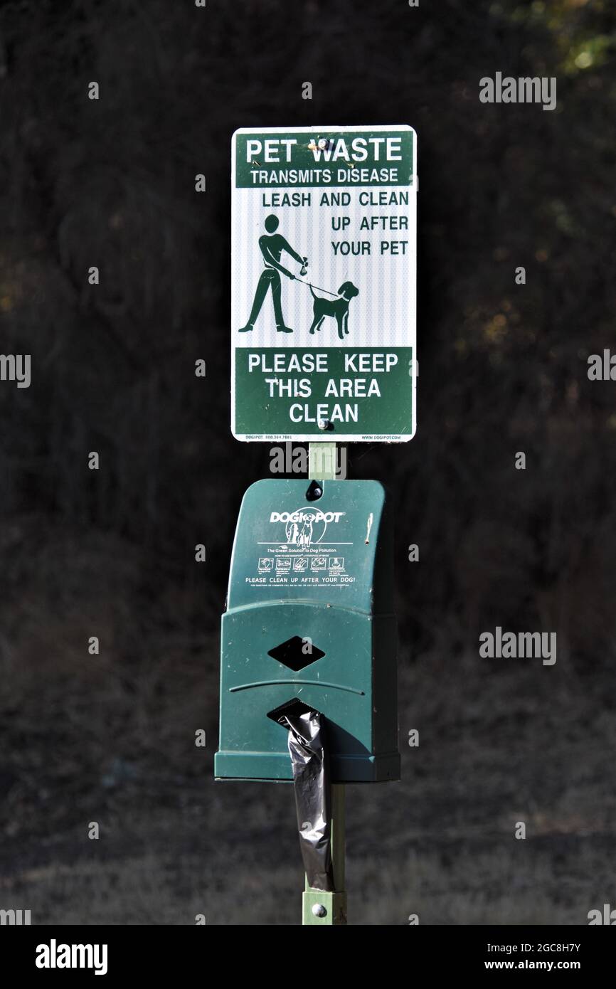 Stazione pubblica di rifiuti per animali domestici per ottenere sacchetti di plastica e poi mettere il doo cane in un cestino dopo che il critter fa la sua cosa sui sentieri della parte Foto Stock